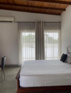 a bedroom with a large bed and a large window at Colombo Residency -Pent House in Kotuwegoda