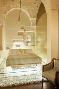 a bedroom with a large bed and a chair at Palazzo Scotto in Alberobello