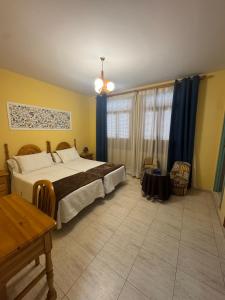ein Schlafzimmer mit einem großen Bett und blauen Vorhängen in der Unterkunft Hostal Joaquín in Ventas con Peña Aguilera