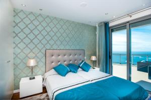 1 dormitorio con 1 cama con almohadas azules y balcón en Villa São Lourenço, en Fajã da Ovelha 22 fotos más