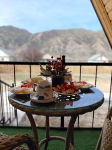 a table with plates of food and flowers on it at Kolsai Star House in Saty