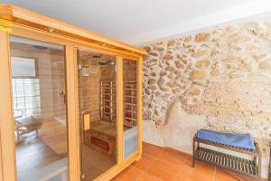 a walk in shower in a room with a stone wall at Hostel El Castillo in Aniñon