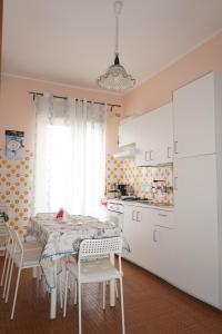 a kitchen with a table and white cabinets at Stella Marina in Giardini Naxos +7 photos