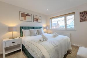 a bedroom with a large white bed with a window at Newhaven in Telford +21 photos