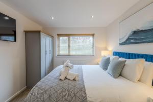 a teddy bear sitting on a bed in a bedroom at Newhaven in Telford