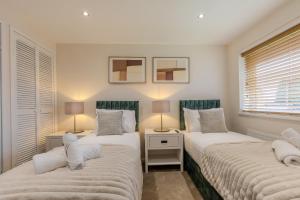 two twin beds in a room with two lamps at Newhaven in Telford