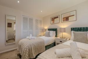 a bedroom with two beds and a mirror at Newhaven in Telford
