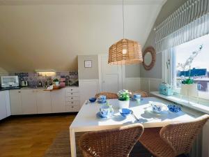 a kitchen with a white table with chairs and a dining room at Prinshöjden Apartments & Villas - Katrineholm Residential in Katrineholm