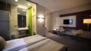 a hotel room with a large bed and a bathroom at Hotel Gorczowski Katowice Chorzów in Chorzów