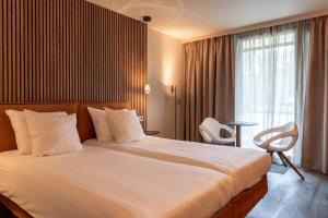 a hotel room with a large bed and a window at Hotel Mitland in Utrecht