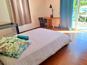a bedroom with a bed and a table and a desk at Villa Dijoux D'O in Entre-Deux