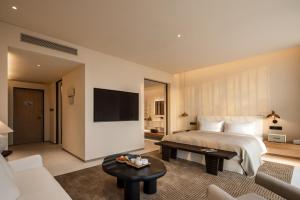 a hotel room with a bed and a tv at PLAN B00b7ANADOL in Xianning
