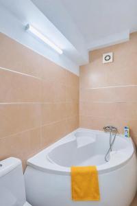 a bathroom with a white tub and a toilet at Victoriei Boutique Apartment in Bucharest
