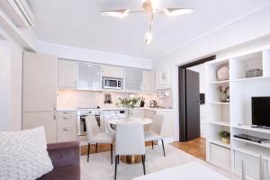 a kitchen and living room with a table and chairs at Victoriei Boutique Apartment in Bucharest +28 photos