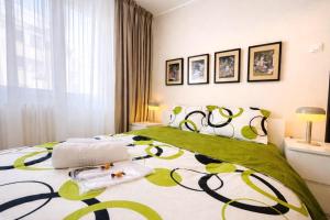 a bedroom with a bed with a green and white bedspread at Victoriei Boutique Apartment in Bucharest