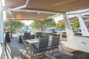 a patio with a table and chairs on a boat at Floating house - Marina Relax in Portorož