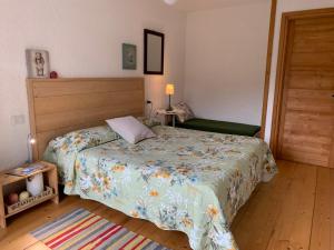 a bedroom with a bed with a floral bedspread at B&b CASCINA CORNELLA in Cremeno