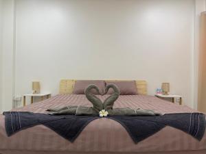 a bed with two heart shaped towels on it at Summer Sand in Haad Rin +18 photos