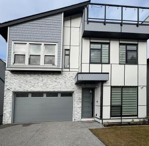 a white brick house with two garage doors at Elevated Horizon Retreat in Chilliwack