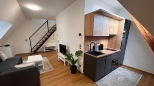 a living room with a kitchen and a staircase at Ulrichova vila a Vilka Rejhotice in Šumperk