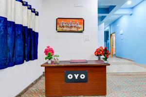 a sign on a desk in a hallway with flowers at Hotel O Blue Valley in Khandagiri