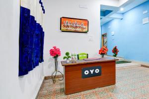 a reception desk in a room with paintings on the wall at Hotel O Blue Valley in Khandagiri
