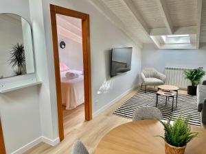 a living room with a table and chairs and a television at Corazón de la Ciudad by apartamentoscatedralcamino in Burgos