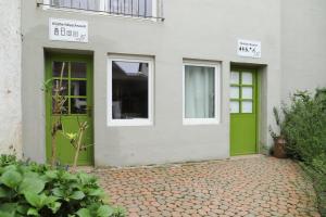 a green door and windows on a white building at Nengshof Gartenhaus Wegerich in Wißmannsdorf