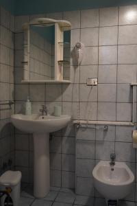 a bathroom with a sink and a mirror and a toilet at Stella Marina in Giardini Naxos