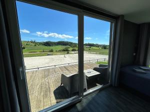 a room with a large window with a view of a field at Apartma Hisa konj in Pernica