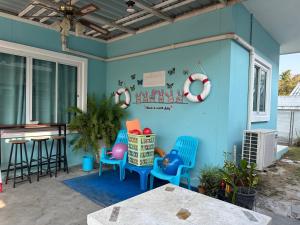 a patio with blue chairs and a table at Baanpeanutsvilla Huahin in Hua Hin