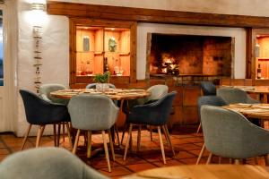 a dining room with tables and chairs and a fireplace at The Farmhouse Hotel in Langebaan +99 photos