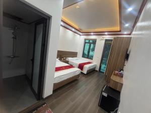 a bedroom with two beds and a mirror at Anh Nhiên Hotel in Ninh Binh +2 photos