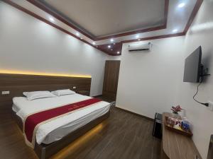 a bedroom with a bed and a flat screen tv at Anh Nhiên Hotel in Ninh Binh