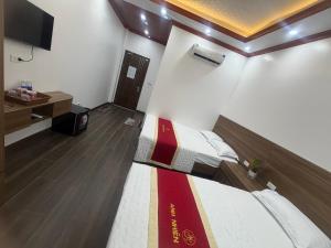 a room with a bed and a tv in it at Anh Nhiên Hotel in Ninh Binh