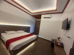 a bedroom with a bed and a flat screen tv at Anh Nhiên Hotel in Ninh Binh