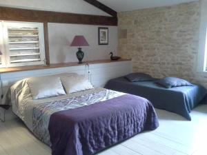 A bed or beds in a room at Le Logis Du Four