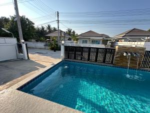 a swimming pool in front of a house at Baanpeanutsvilla Huahin in Hua Hin