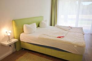 a bedroom with a large bed with a window at Golfresidenz D 0 06 in Grömitz +15 photos