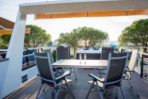 a table and chairs on the deck of a house at Floating house - Marina Relax in Portorož