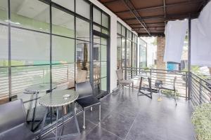 a balcony with tables and chairs in a building at SANS Stay Raja Soeta Hostel Lampung in Hajimana
