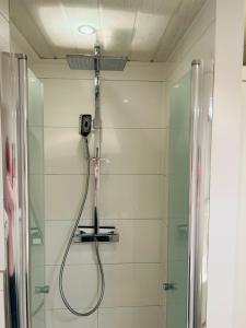 a bathroom with a shower with a camera on the wall at Kliffblick am Watt in Wenningstedt +10 photos