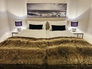 a bedroom with a large bed with two lamps at Kliffblick am Watt in Wenningstedt
