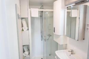 a white bathroom with a shower and a sink at Floating house - Marina Relax in Portorož