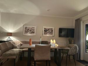 a dining room with a table and chairs and a television at Kliffblick am Watt in Wenningstedt