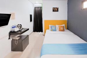 a small room with two beds and a desk at SANS Stay Raja Soeta Hostel Lampung in Hajimana