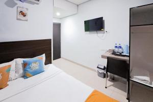 a hotel room with a bed and a desk at SANS Stay Raja Soeta Hostel Lampung in Hajimana