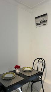 a black table with two plates and two chairs at Little apartment in Hammamet +1 photo