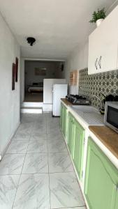 a kitchen with green cabinets and a white refrigerator at Little apartment in Hammamet