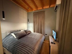 a bedroom with a bed and a flat screen tv at Pastorian Hotel in Maliq +32 photos